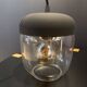 Portable lamp with transparent glass and black plastic.