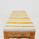 Vintage oak bench with striped linen fabric in a country style.