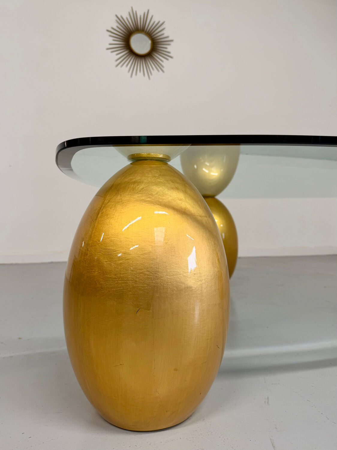 Vintage Italian design coffee table with a glass top and gold base, dating from the 1980s.