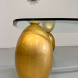 Vintage Italian design coffee table with a glass top and gold base, dating from the 1980s.