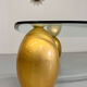 Vintage Italian design coffee table with a glass top and gold base, dating from the 1980s.
