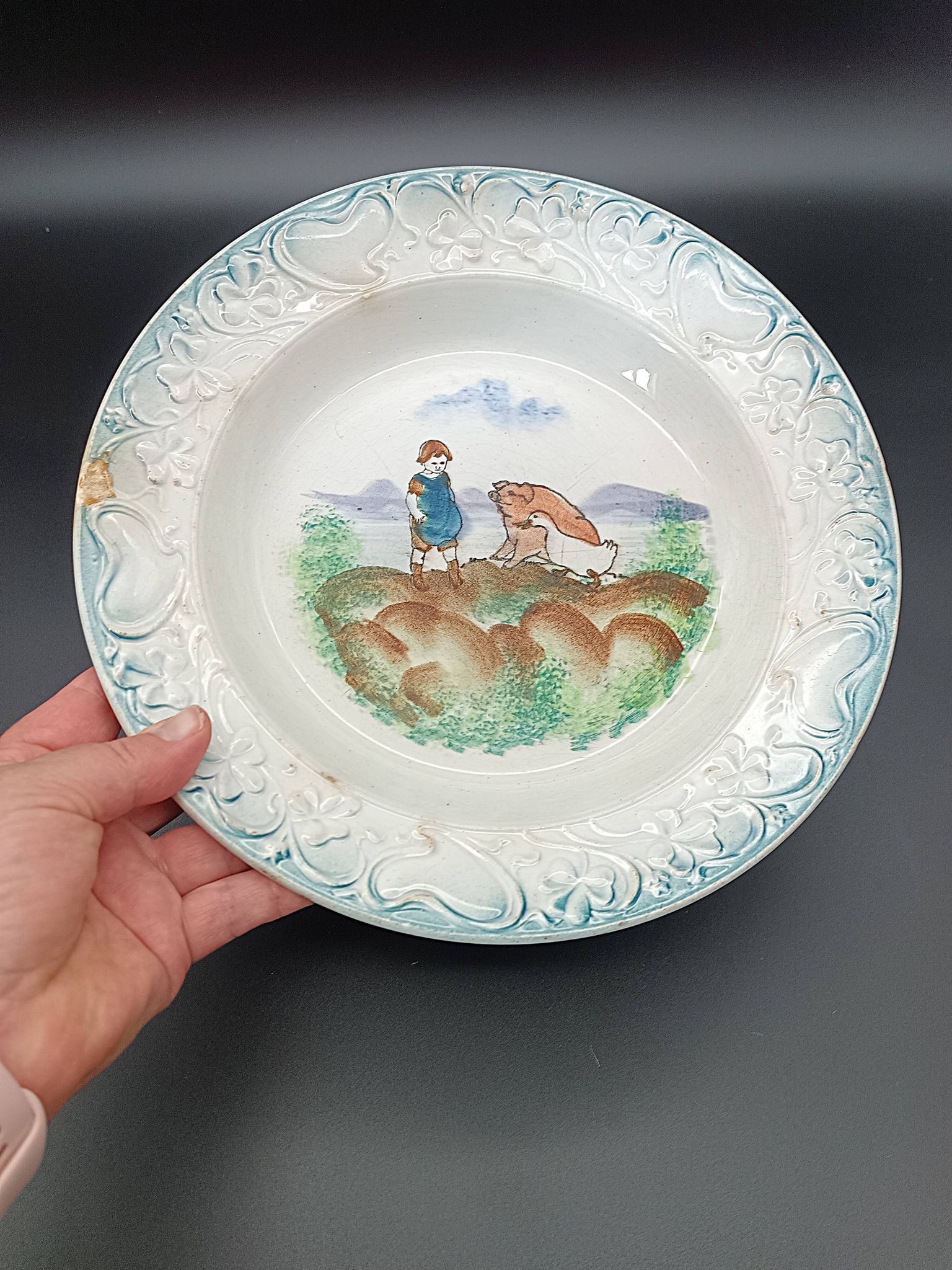 Large antique hollow dish from the 19th century, earthenware with pastoral decoration featuring a child, pig, and goose.