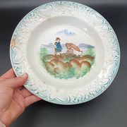 Large antique hollow dish from the 19th century, earthenware with pastoral decoration featuring a child, pig, and goose.