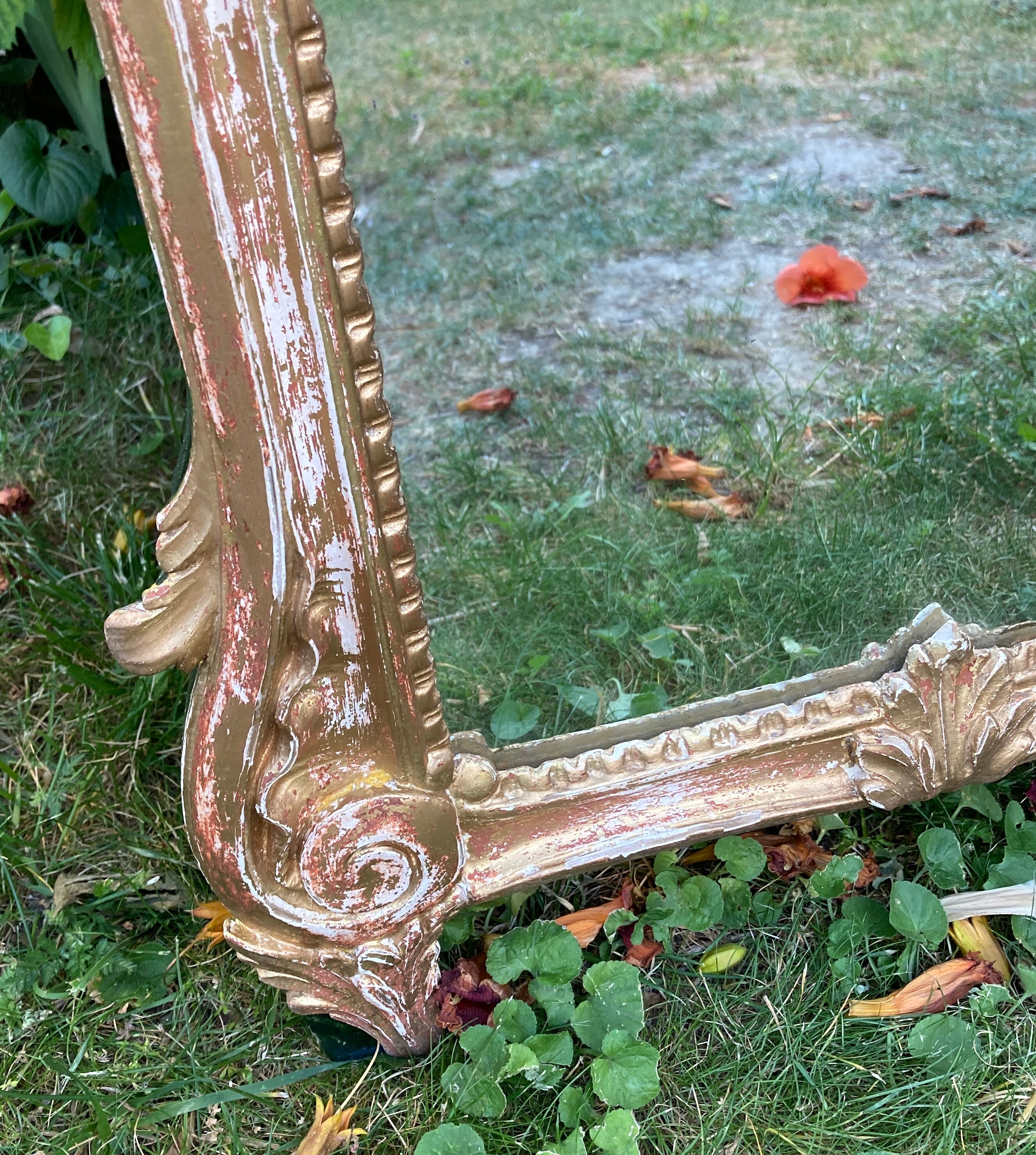 Mirror above a wooden and gilded stucco fireplace in the style of the 18th century.