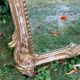 Mirror above a wooden and gilded stucco fireplace in the style of the 18th century.