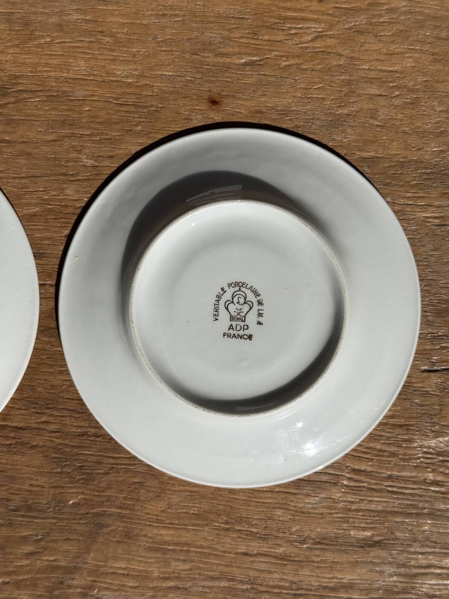 Pair of white porcelain cups from ADP France with a floral pattern and their s