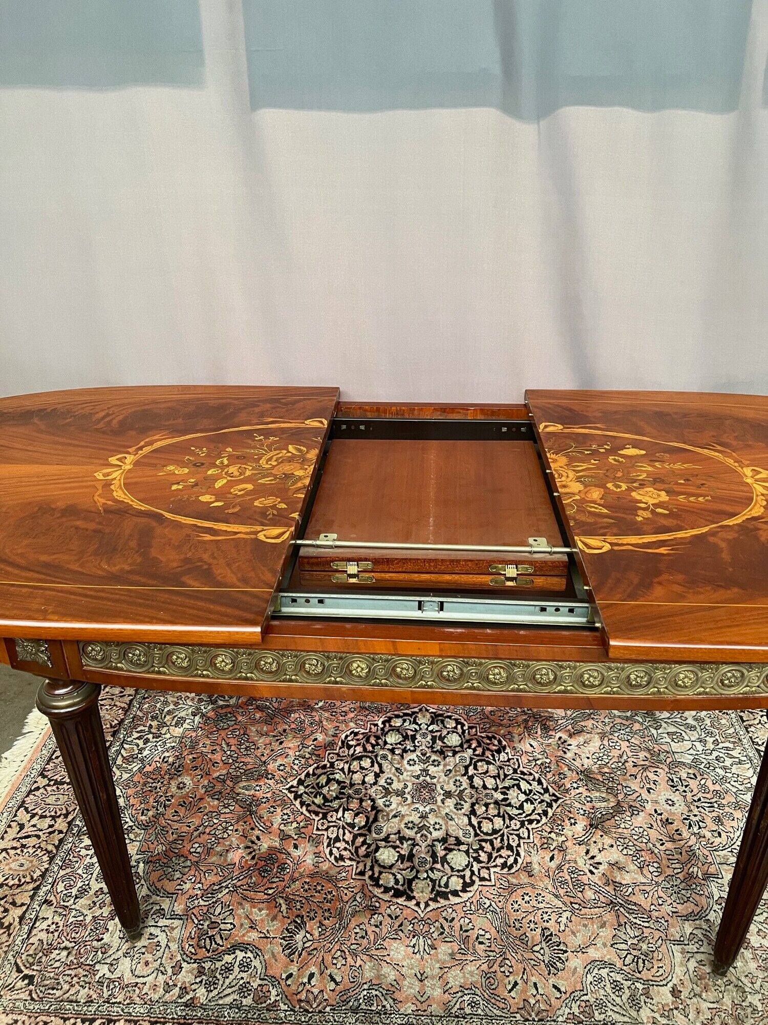 Louis XVI style oval dining table with rosewood marquetry extension mounted in bronze