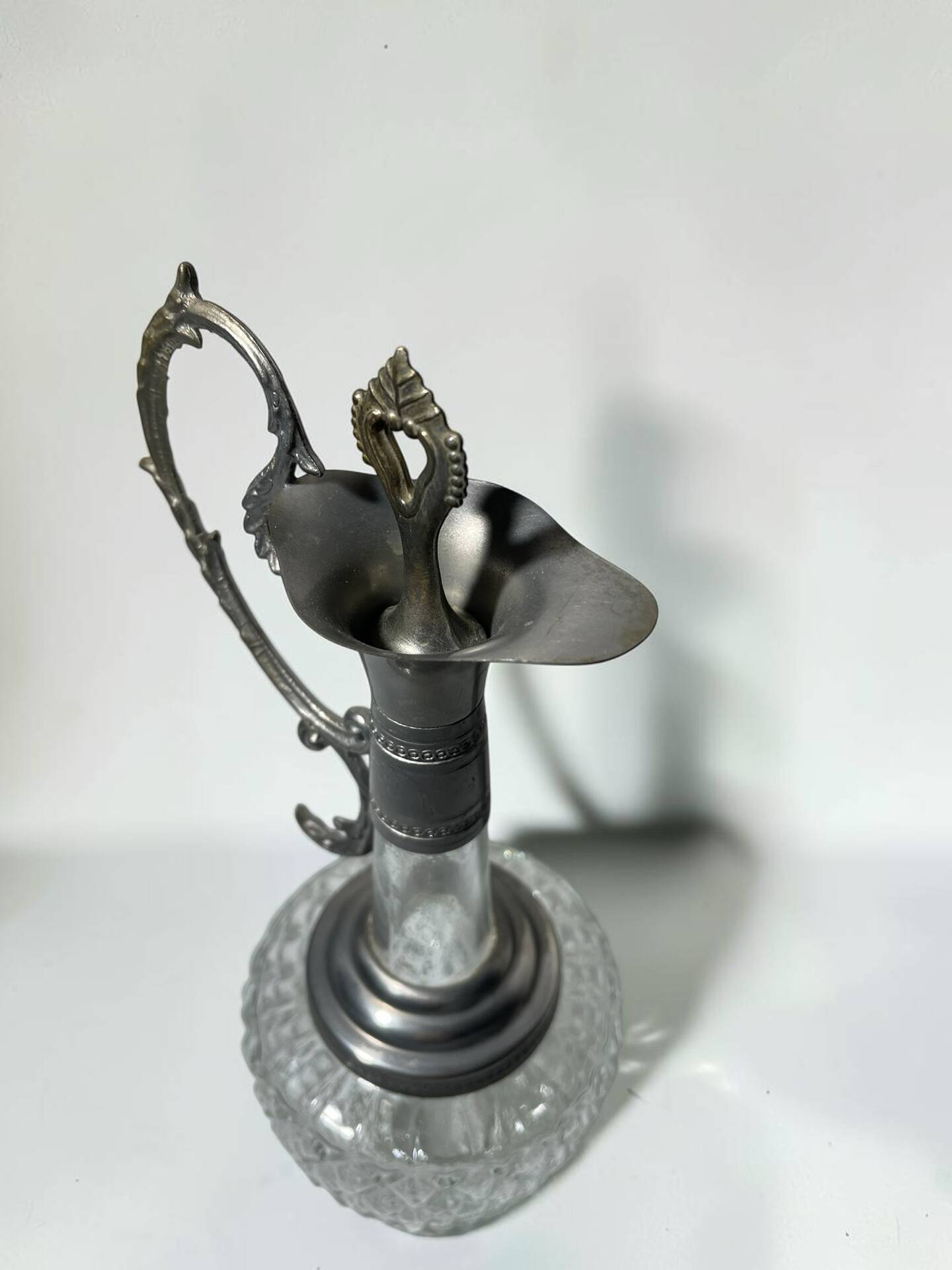 Vintage glass decanter with cut design and silver-plated metal, stopper included.