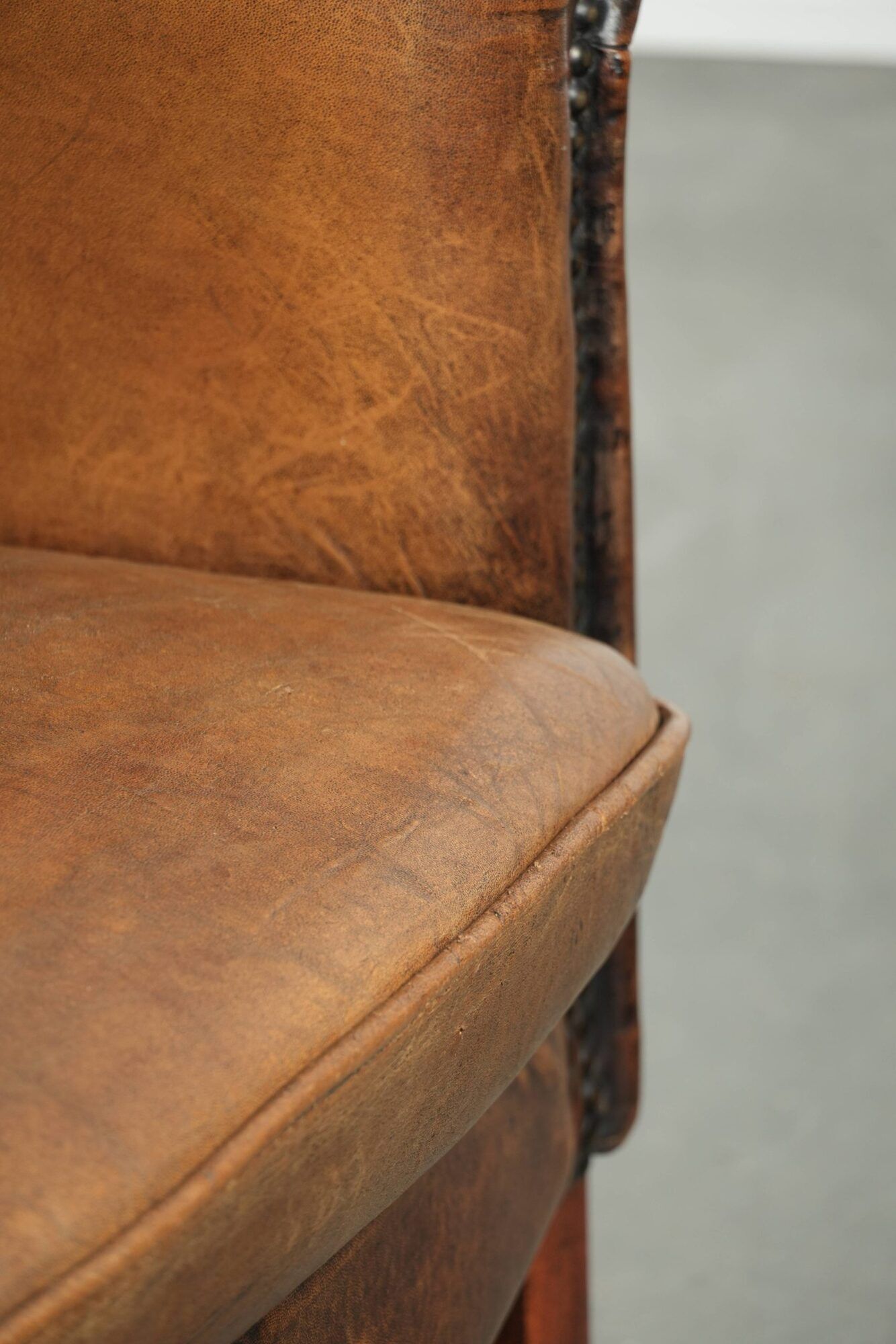Sheepskin club armchair in a brown colour finished with decorative nails