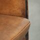 Sheepskin club armchair in a brown colour finished with decorative nails