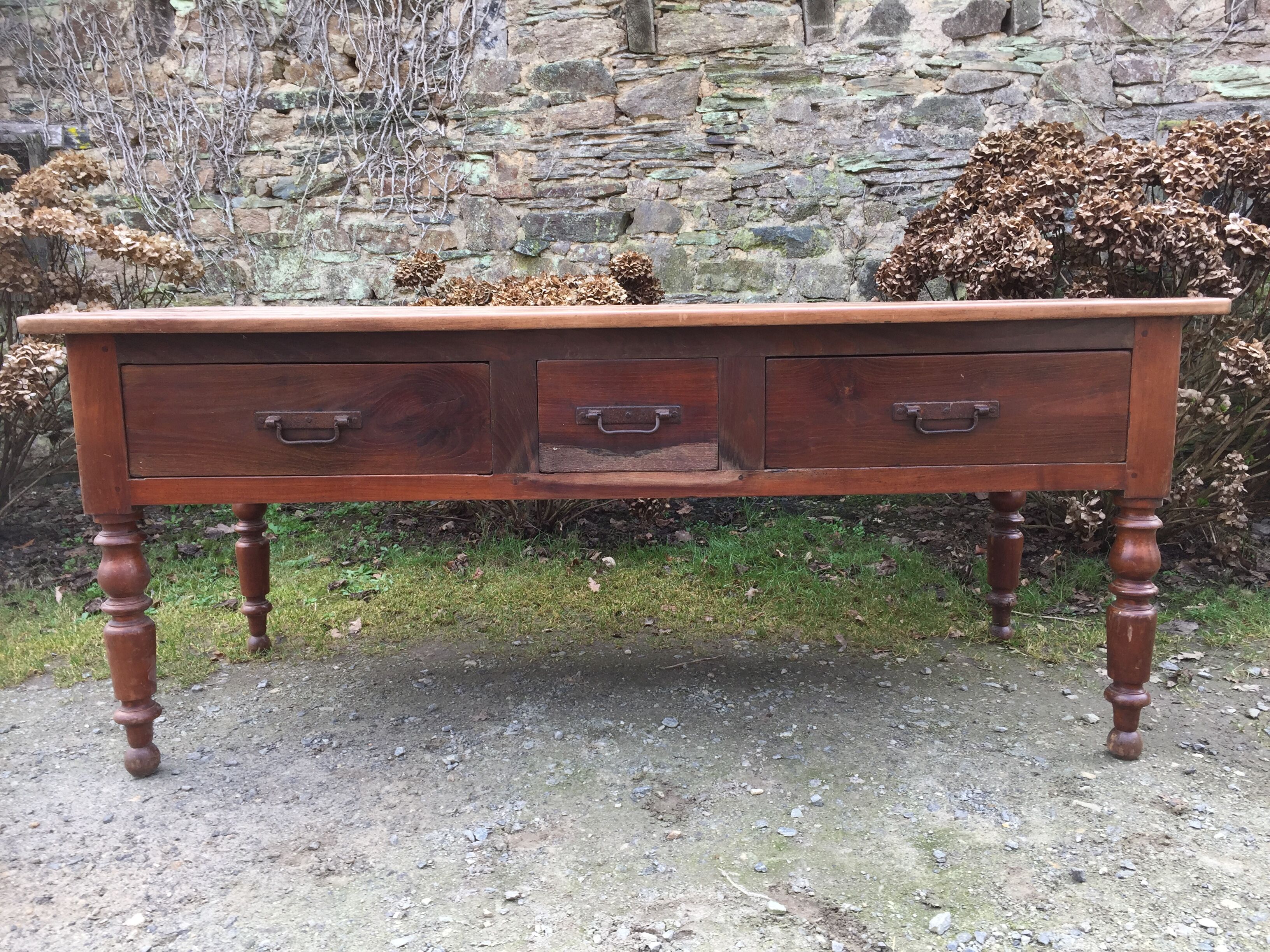 Old farmhouse table with cherry and chestnut panels with 3 drawers.