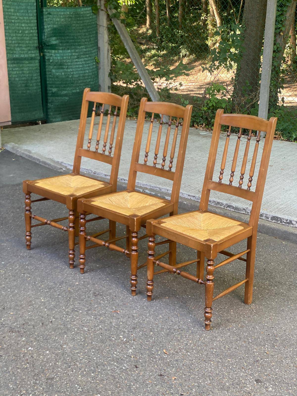 Solid wood chair with a straw seat and carved bar backrest.