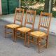 Solid wood chair with a straw seat and carved bar backrest.