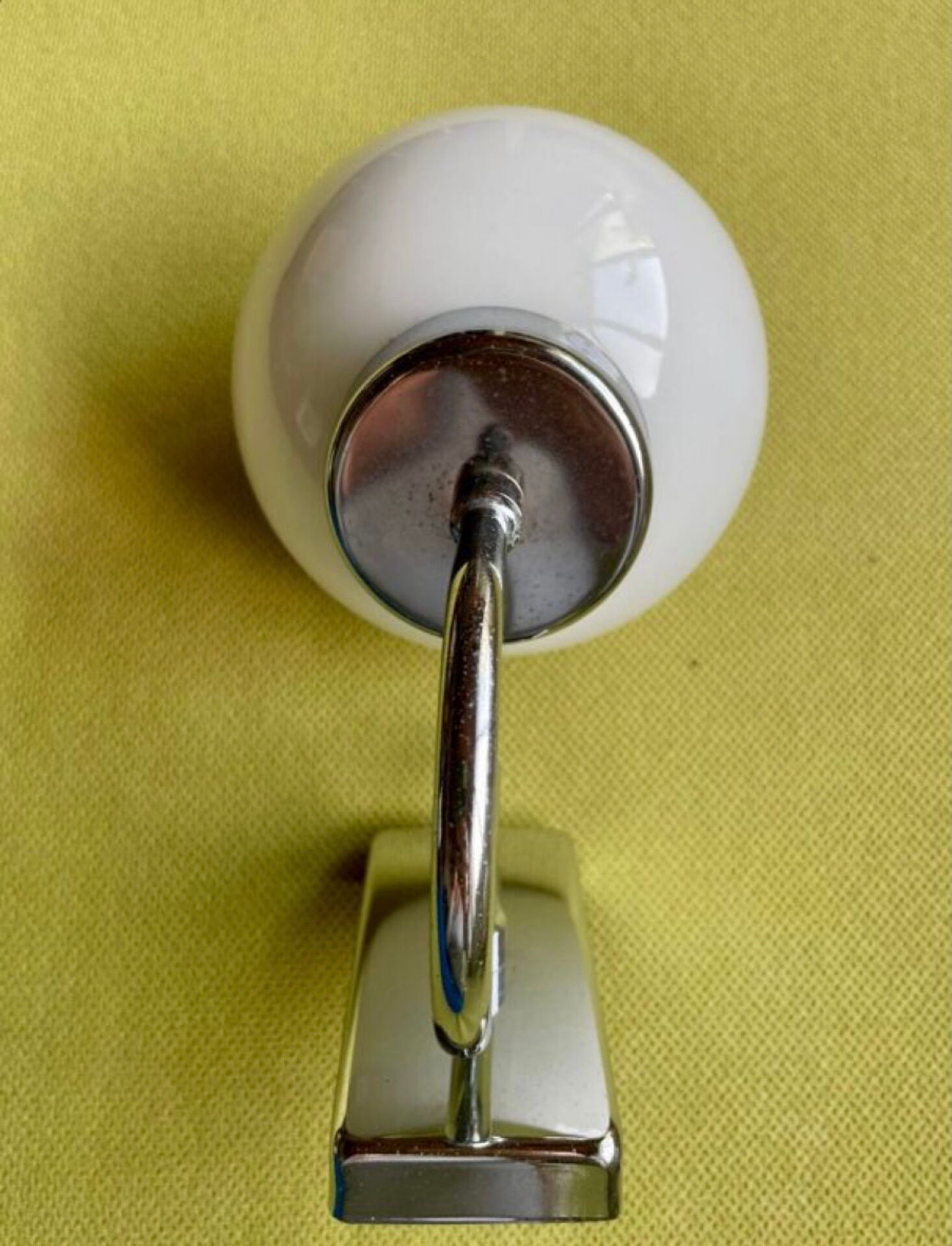 Pair of chrome metal wall lights with white glass globe.