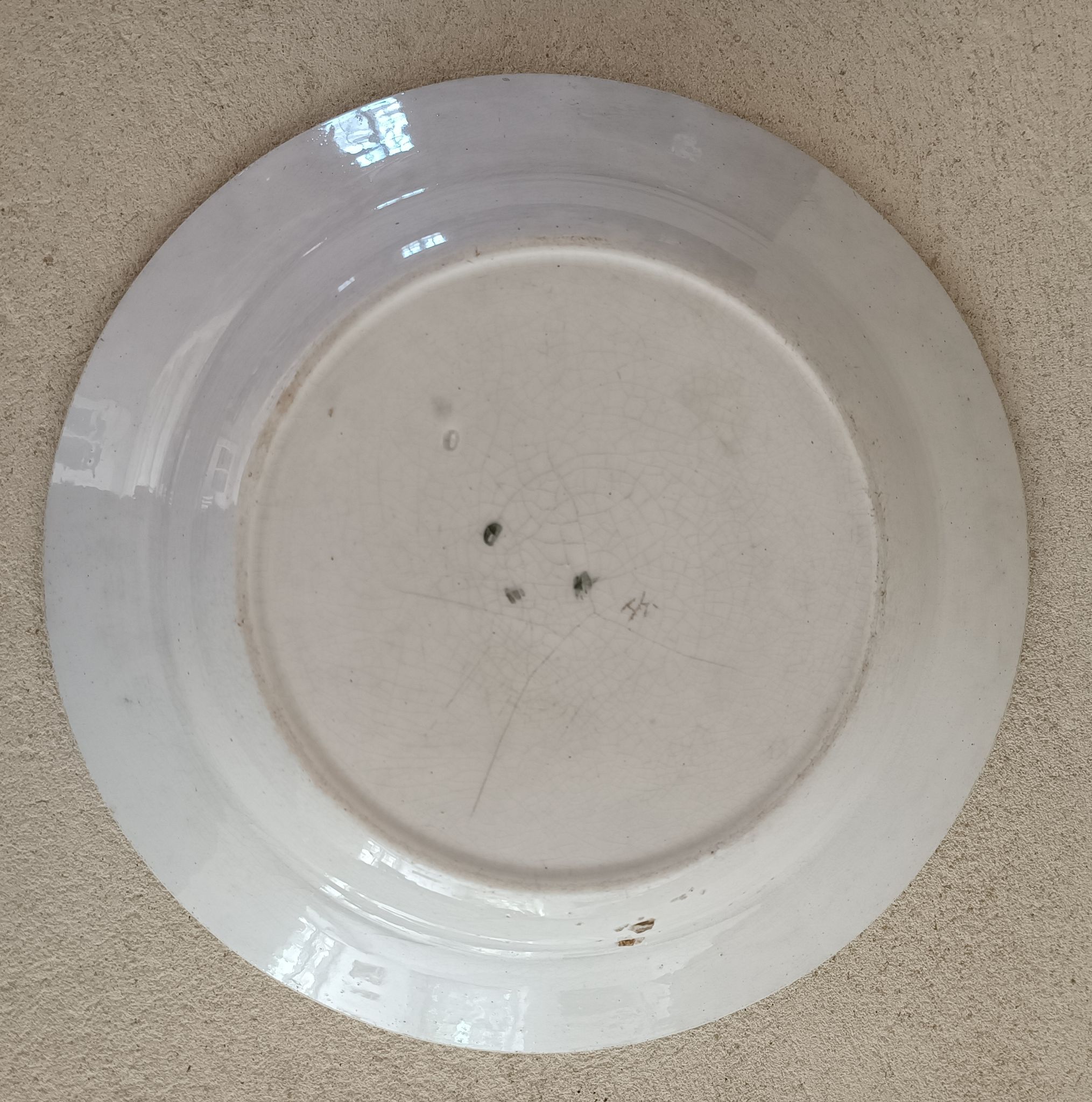 Plat de service terre de fer à décor d'enfant et cigogne