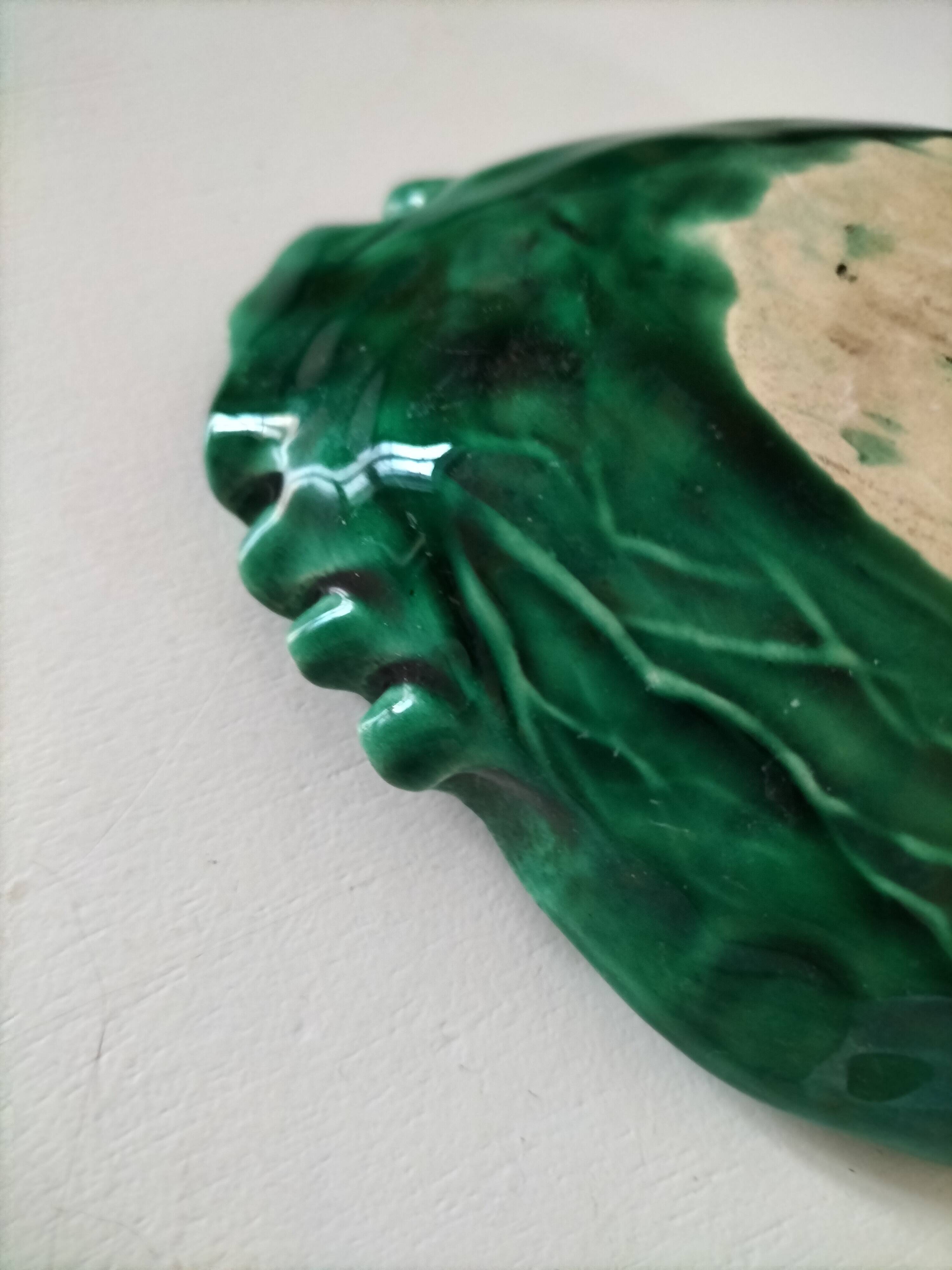 Vintage green slipware bowl in the shape of a cabbage leaf.