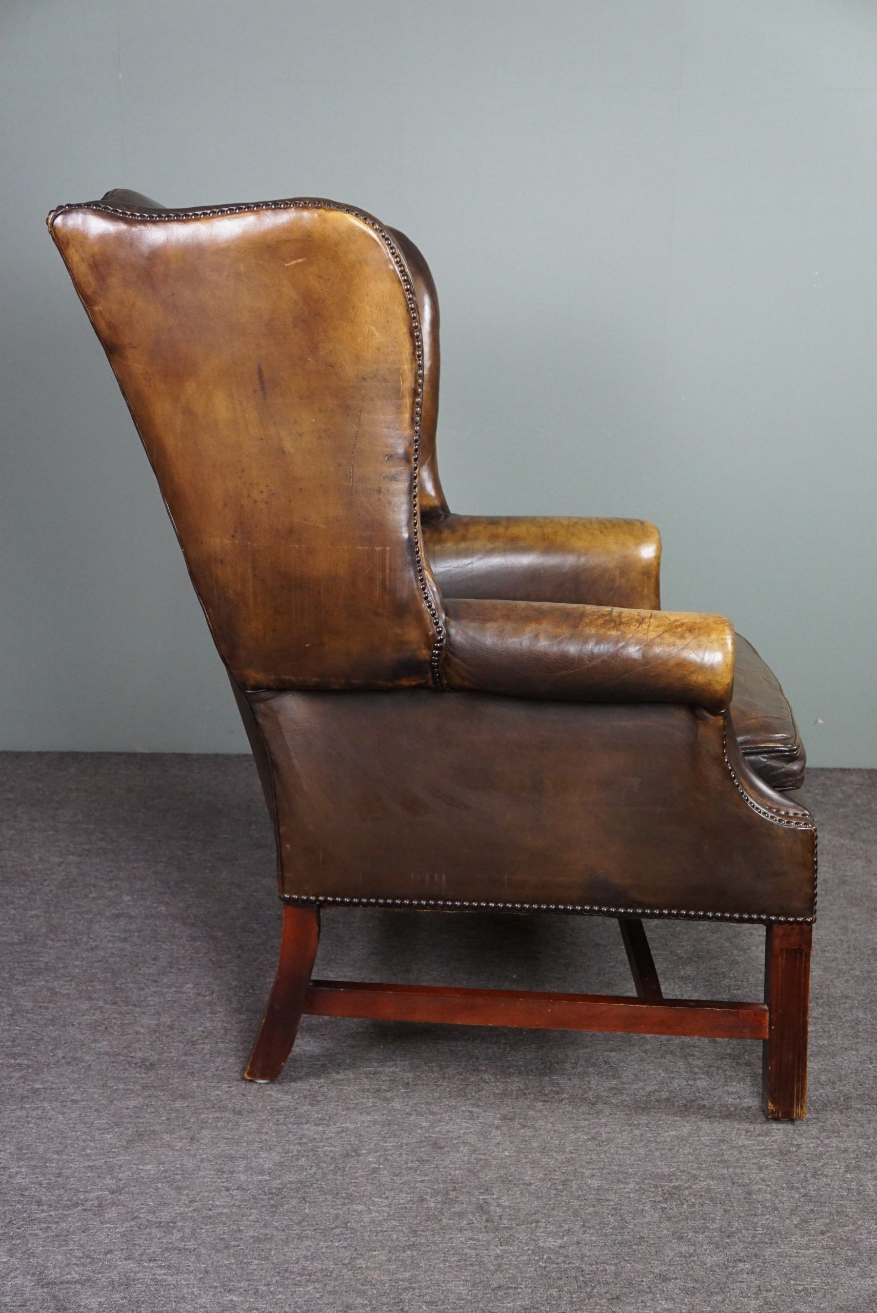 Patinated cowhide leather armchair