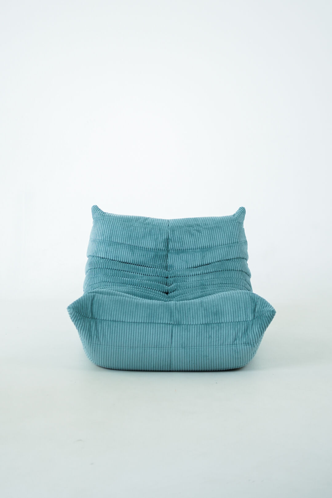 Ensemble de fauteuil et pouf Togo en velours côtelé bleu clair.