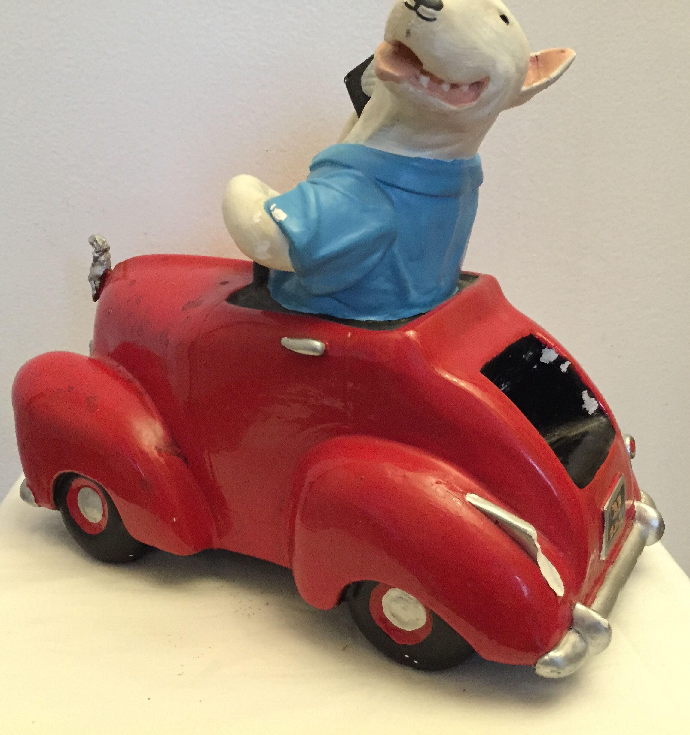 Dog toy driving his red car