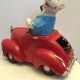Dog toy driving his red car