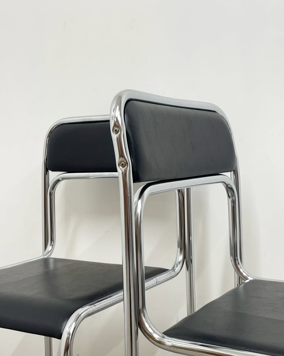 4 chrome metal chairs with black faux leather, 1990