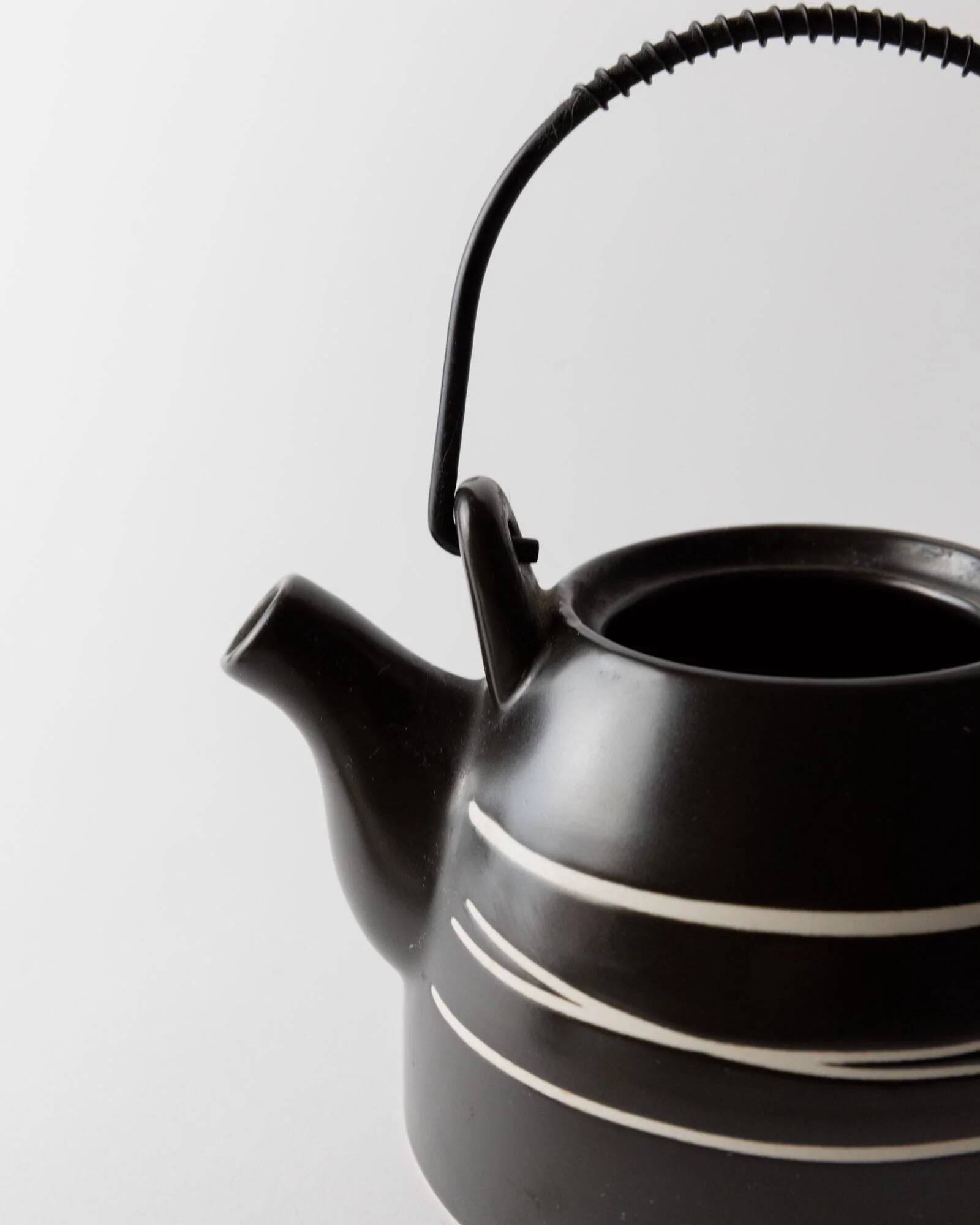 Vintage ceramic teapot from the 1980s, black with white stripes and a metal handle.