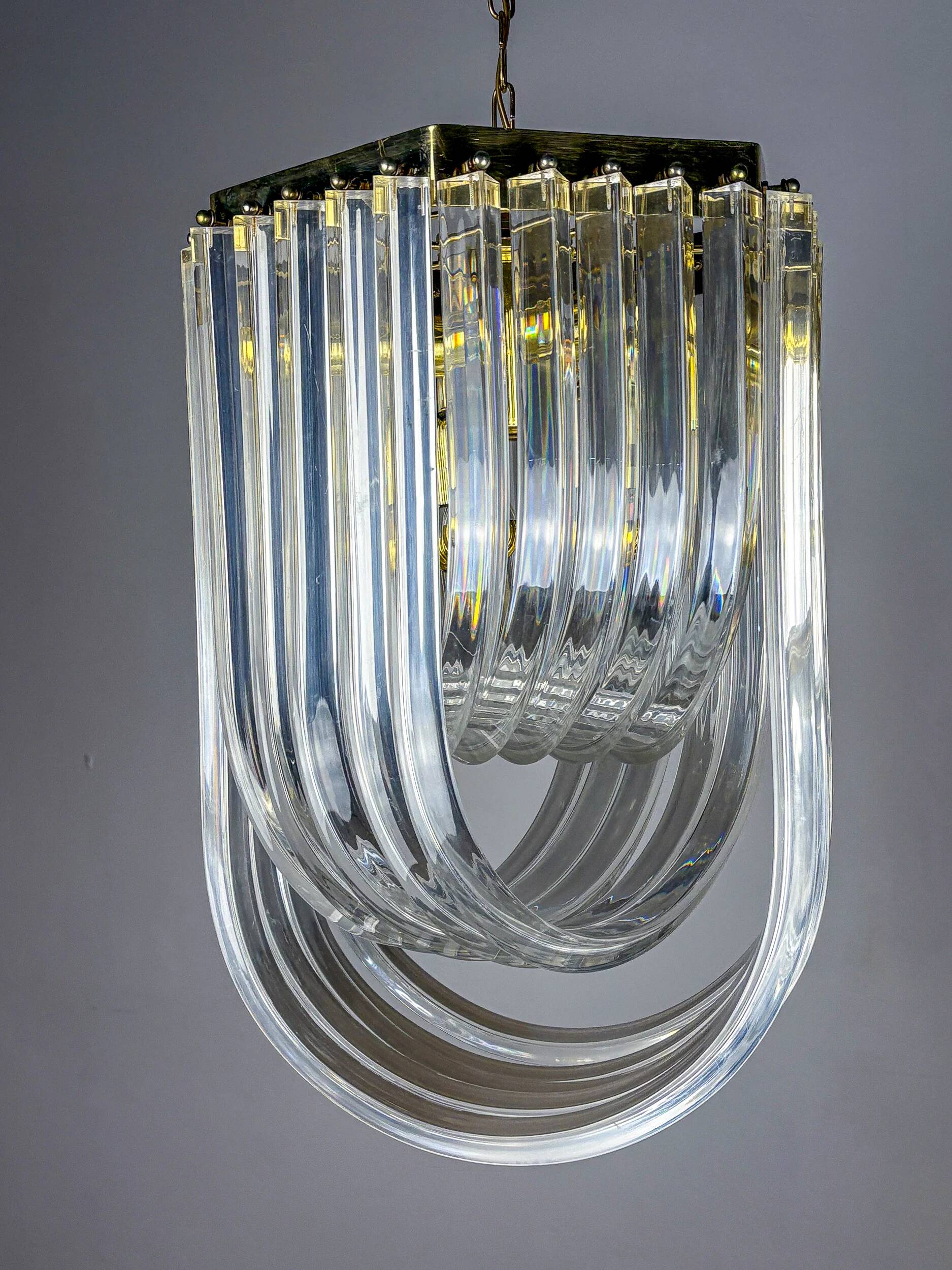 Long mid-century curved Lucite ribbon chandelier in brass, Italy