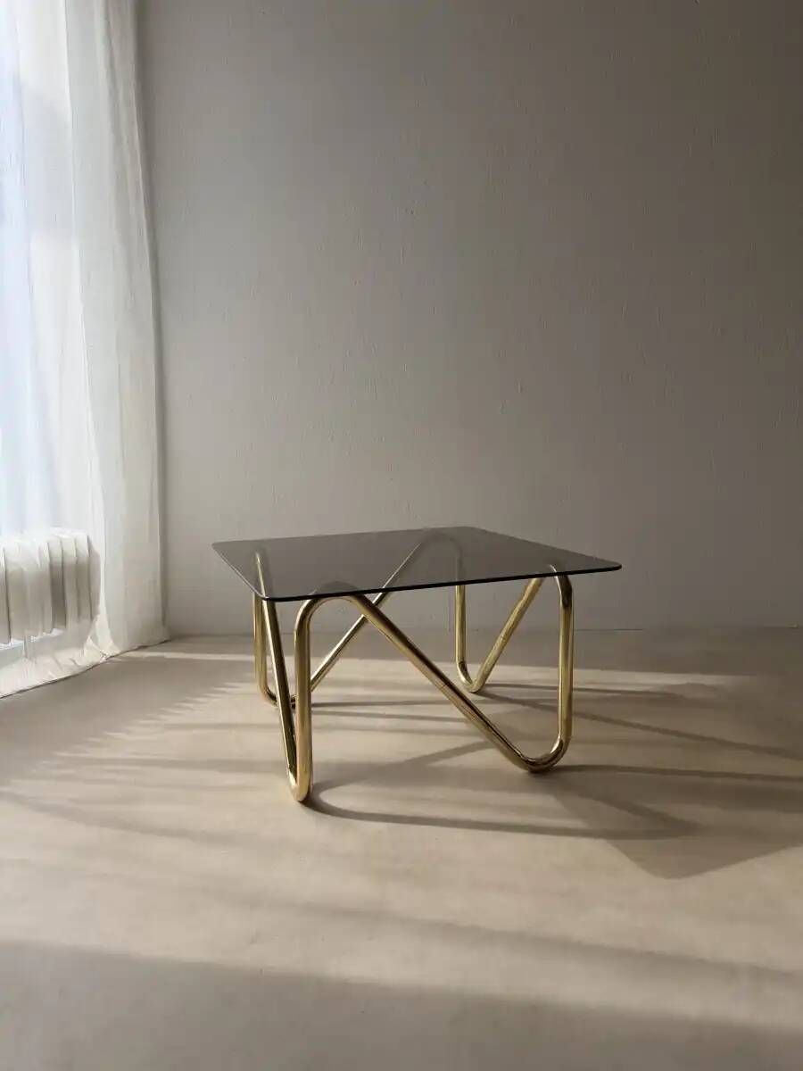 Coffee table with smoked glass and curved metal base