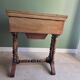 Antique wooden sewing cabinet with mirror and storage.