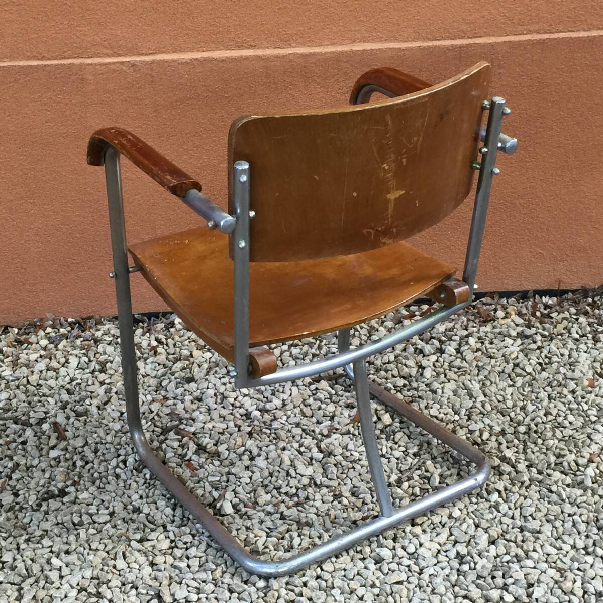 Modernist armchair in plywood, screwed steel tubes