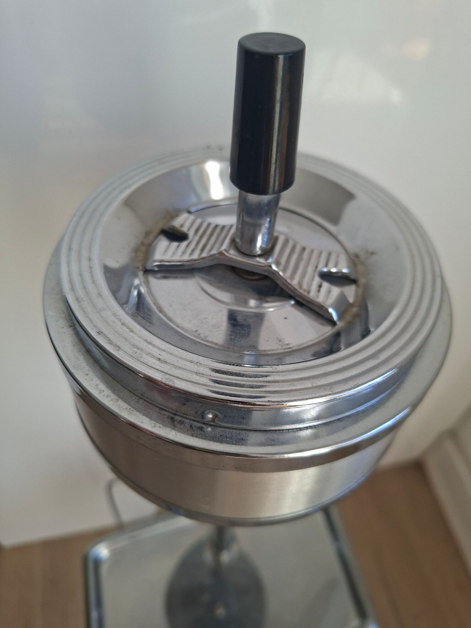 Vintage chrome metal floor ashtray with integrated tray.