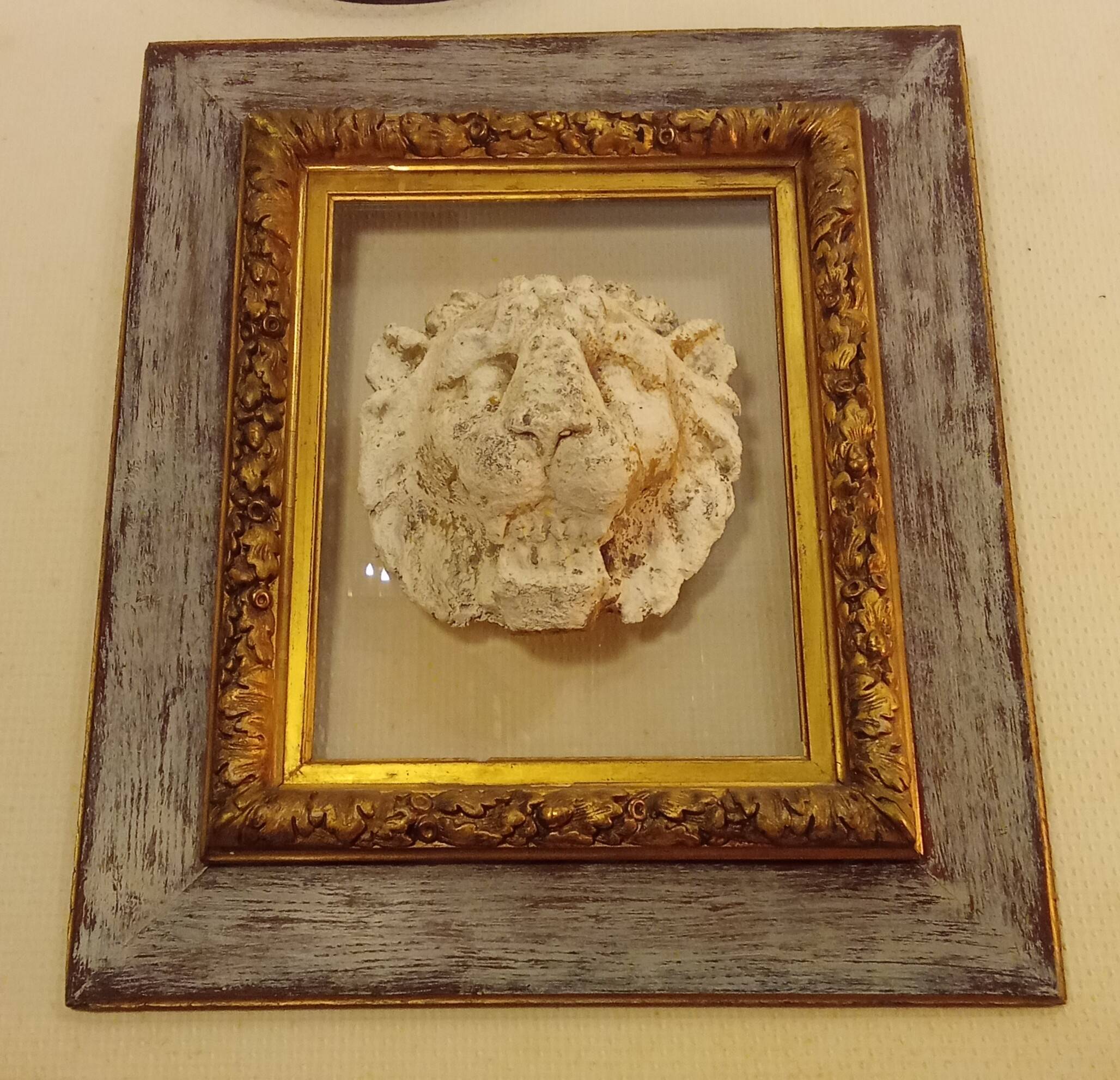 Antique gilded frame with stone lion head ornament on plexiglass