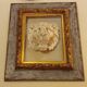 Antique gilded frame with stone lion head ornament on plexiglass