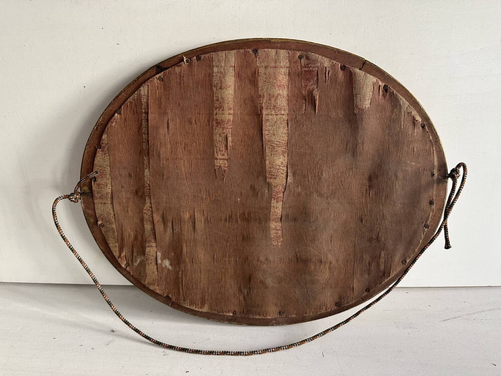 Antique oval mirror in gilded wood, bevelled mercury glass, 19th century.