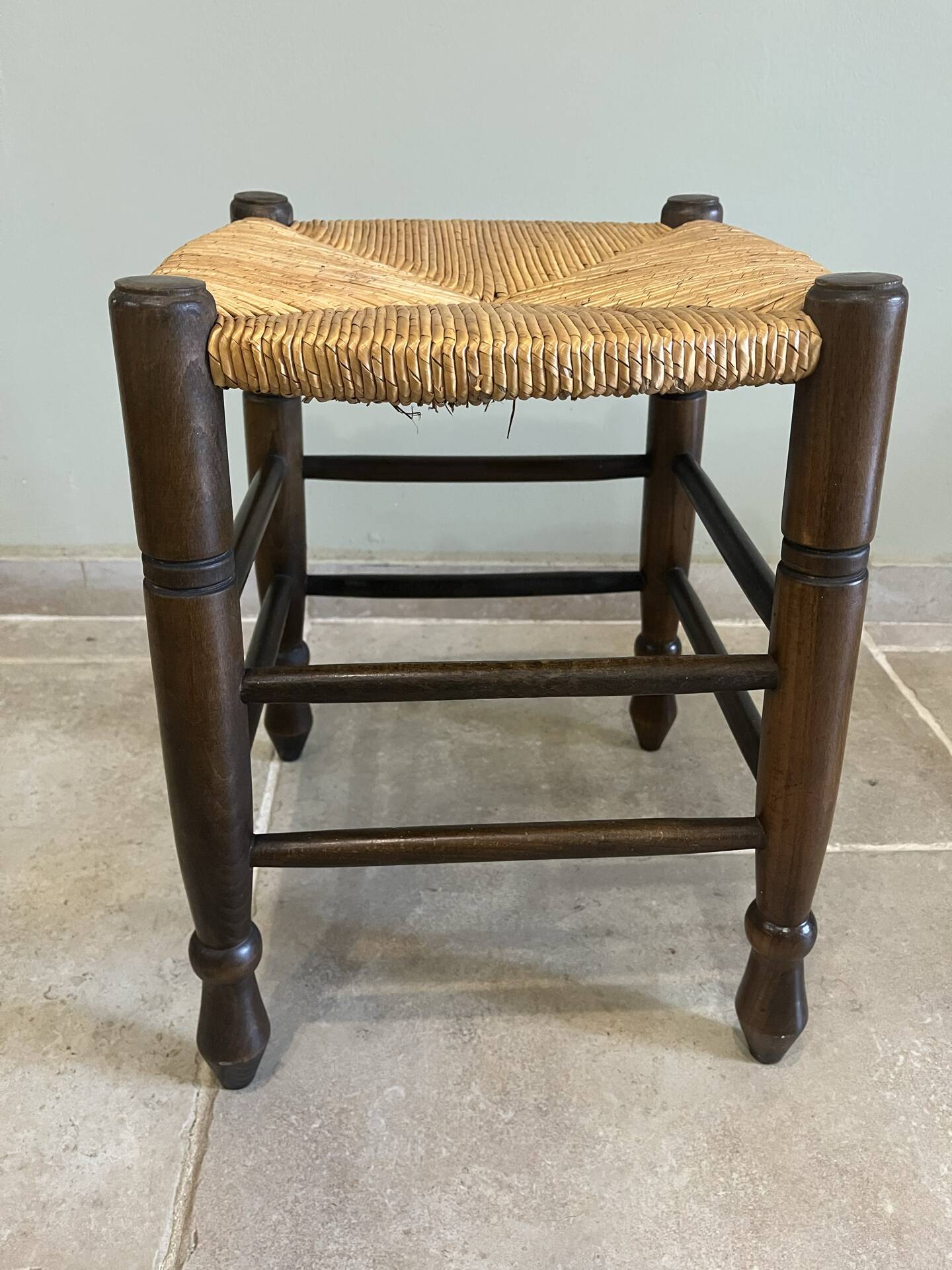 Wooden stool with a straw seat