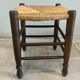 Wooden stool with a straw seat