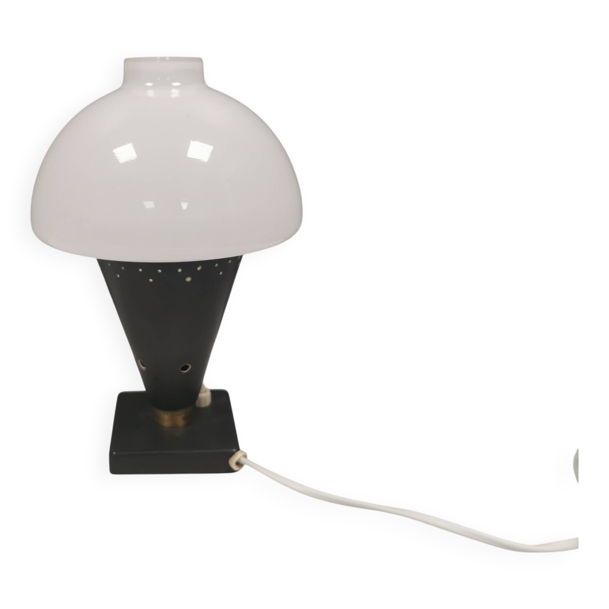 Small stylish table lamp with perforations and milky white opal glass shade