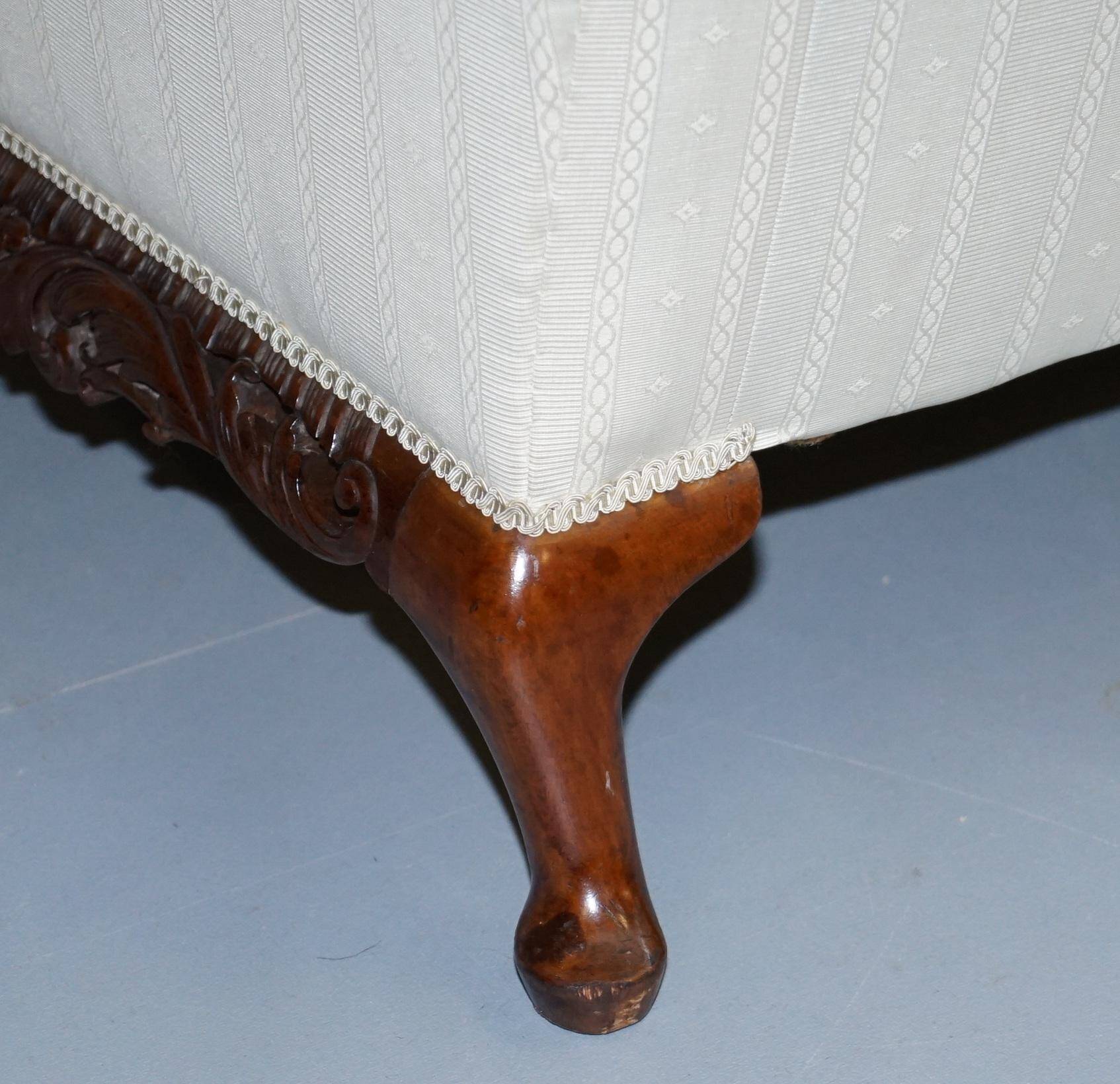 Three-seater canapé carved from solid walnut with claw feet.