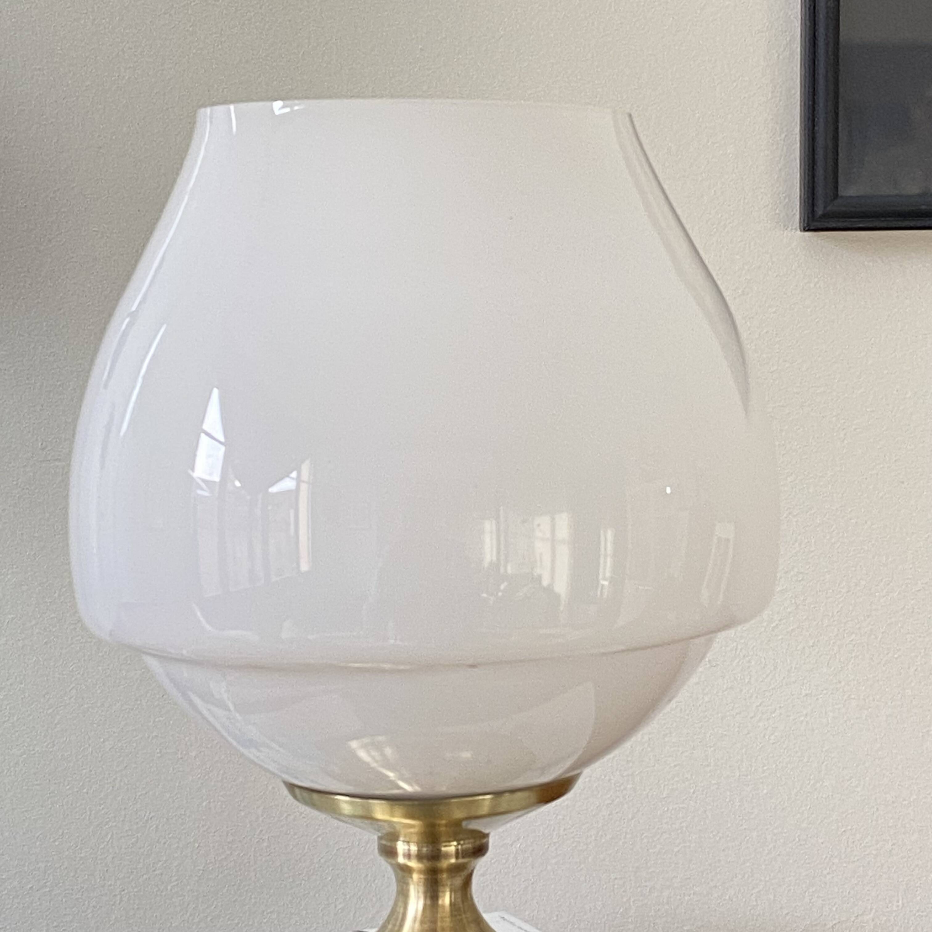 Antique white opaline glass globe table lamp with a brass base.