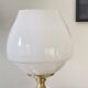 Antique white opaline glass globe table lamp with a brass base.