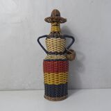 Old bottle dressed in scoubidou style rattan