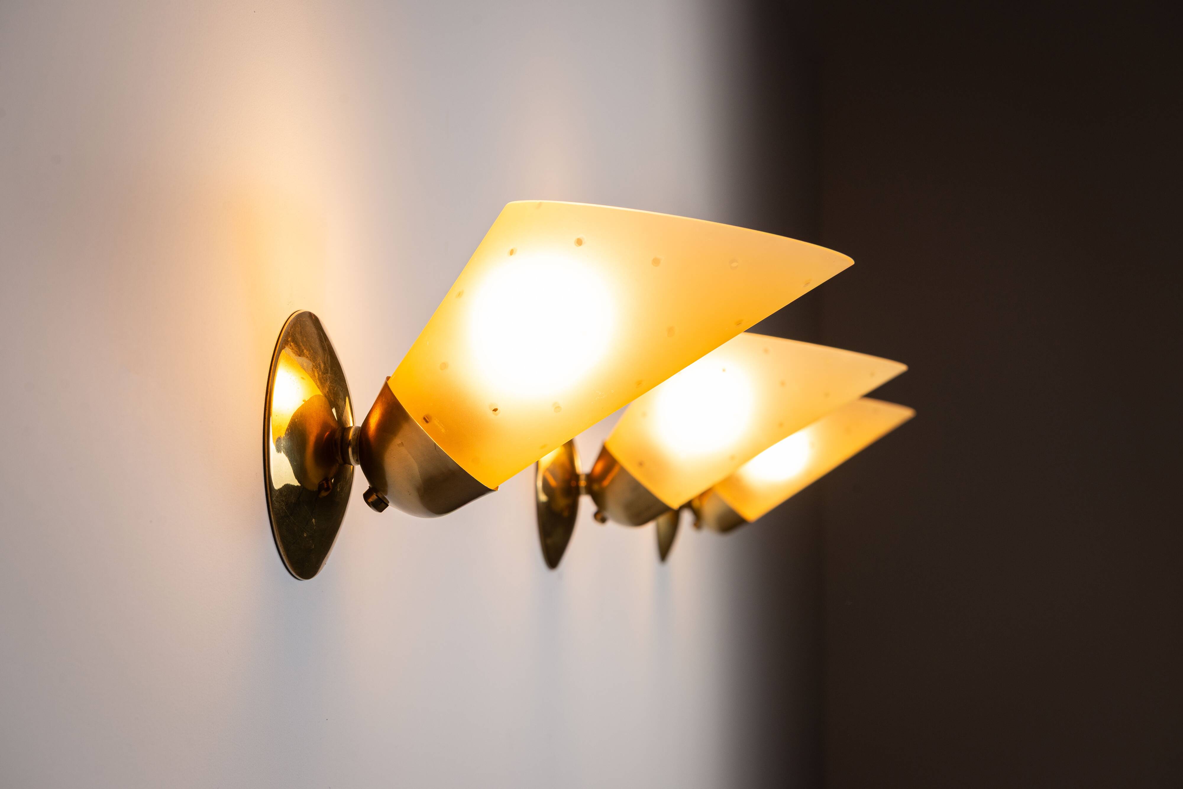 Set of three brass sconces with decorated yellow glass shades