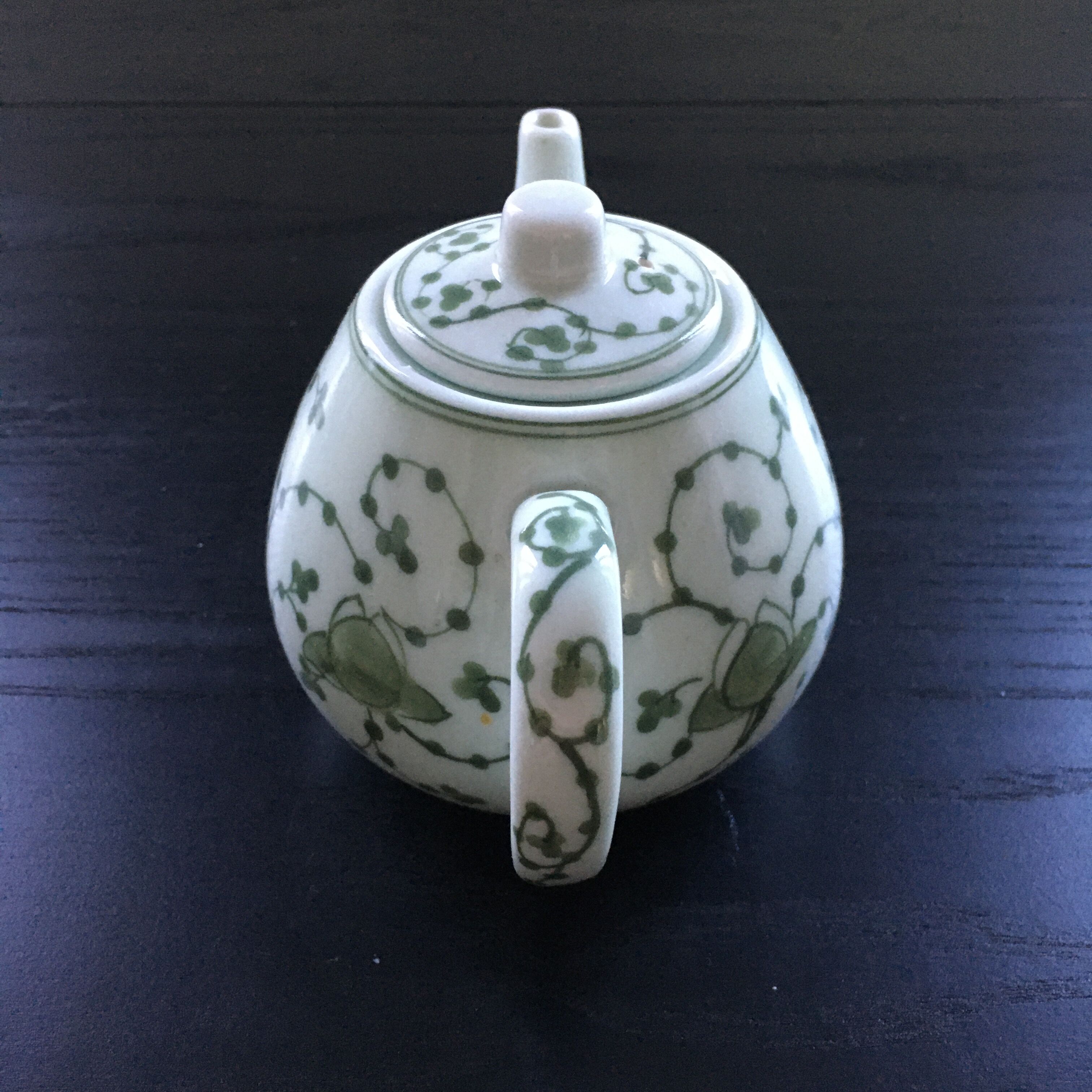 Green plant-decorated teapot