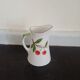 Small ancient porcelain pitcher decorated with cherries