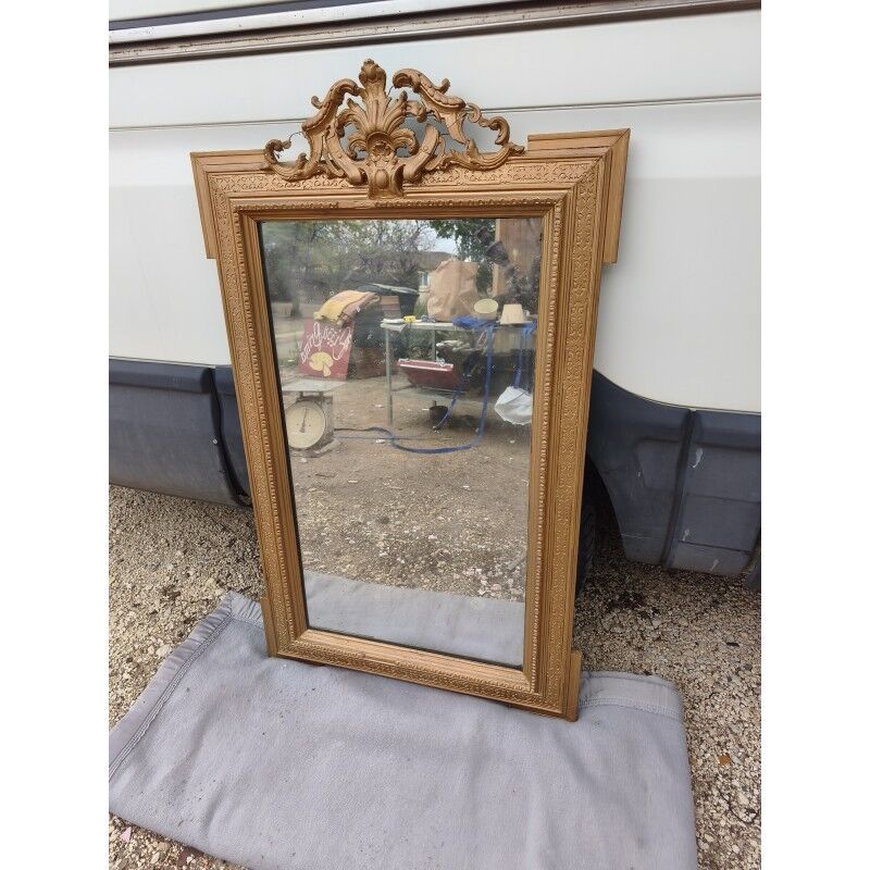 19th-century mirror in gilded wood and stucco.