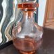 Vintage glass carafe in pink-orange, retro-chic style.