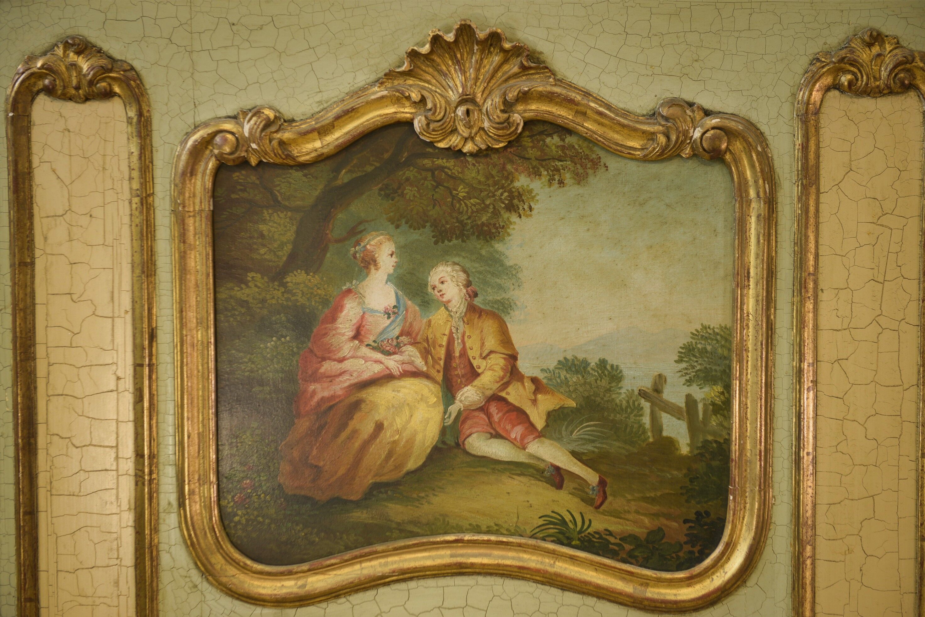 Trumeau mirror with cracked patina and oil on panel depicting a romantic scene from the 19th century.