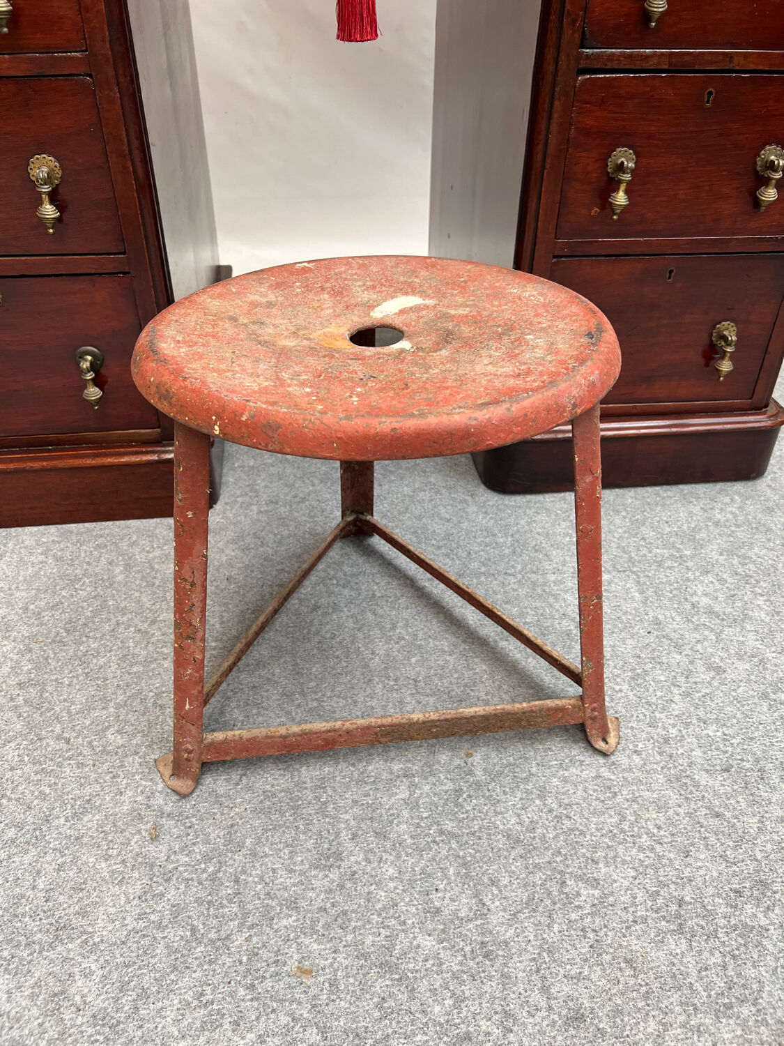 Red tripod industrial metal stool