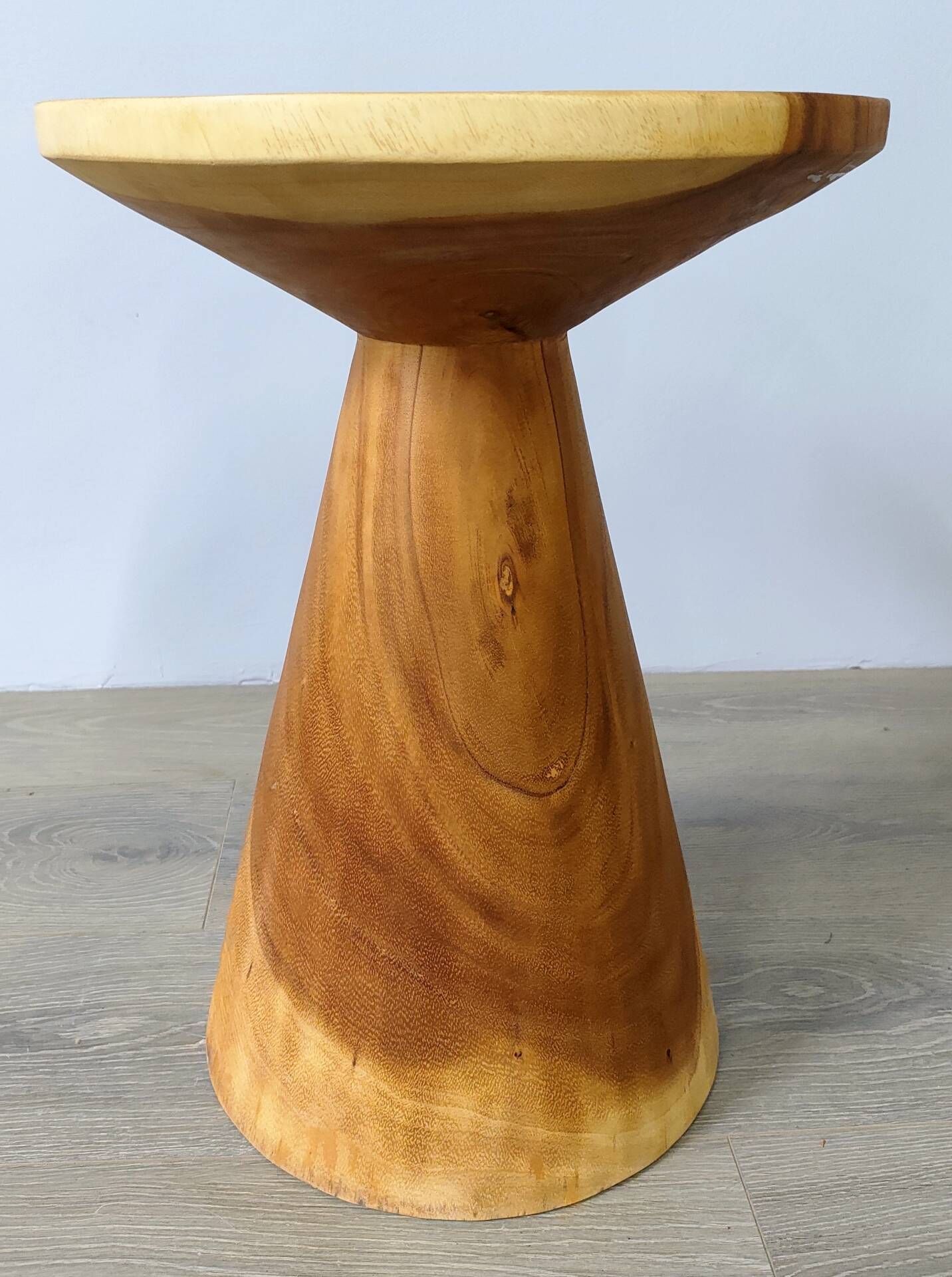 Minimalist side table in solid suar wood with conical legs.