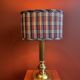 Lamp base in gilded brass, oval silk lampshade with a checkered pattern in burgundy.